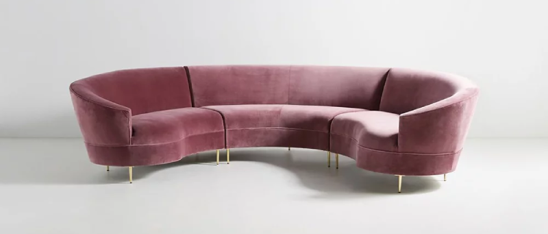 Sofa hình vòng cung hồng kết hợp nỉ nhung tạo nên một điểm nhấn độc đáo và hiện đại trong phòng khách.